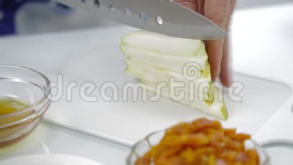 特写女人她的手在厨房的砧板上切梨烹饪健康的食物视频的预览图