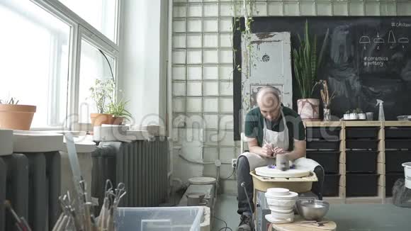 在陶器车间工匠用工具切割粘土碗的形状视频的预览图