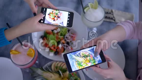 博客智能手机在手女朋友在早餐期间为社交媒体拍摄有用的素食照片视频的预览图