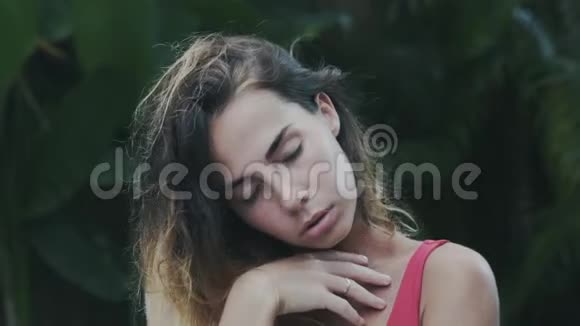 一个特写的慢镜头女孩在别墅里休息一头黑色的卷发被扔到一边旋转着头视频的预览图
