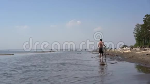 一个年轻人带着一块滑板沿着海岸走视频的预览图