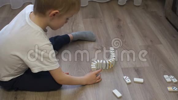 一个小男孩的特写镜头在一条多色点的多米诺骨牌长路上视频的预览图