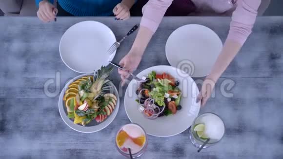 饮食和休闲可以看到女孩在餐桌上吃晚餐和供应沙拉以及健康食品和饮料视频的预览图