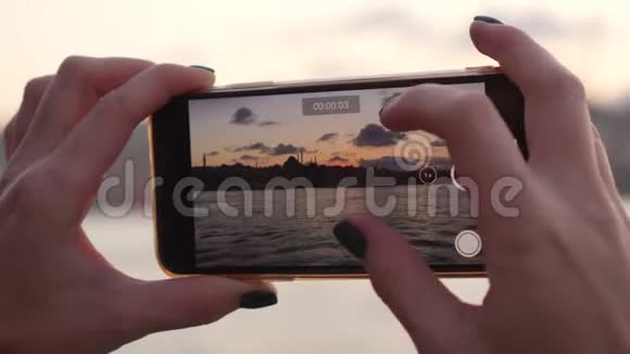 女人拍视频的时候手握智能手机视频的预览图