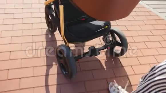 婴儿车马车婴儿车在夏季的长廊近距离拍摄婴儿车前轮近距离射击视频的预览图