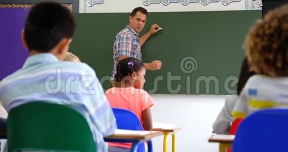 高加索男教师在4k教室白板上教学童的侧视图视频的预览图
