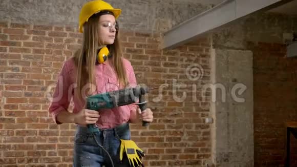 年轻认真的女建筑工人手里拿着钻打开建筑构思视频的预览图
