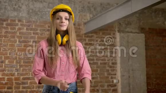 年轻漂亮的女建筑工人正交叉双臂微笑着看着镜头砖背景视频的预览图
