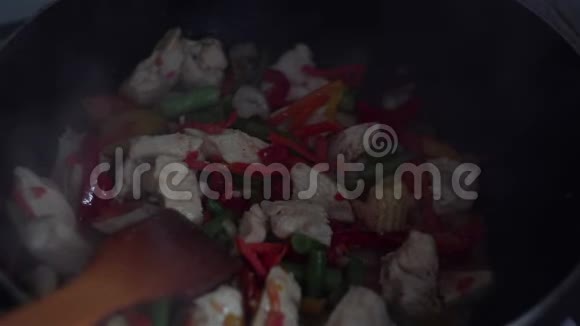 厨师用炒锅煮鸡和蔬菜视频的预览图