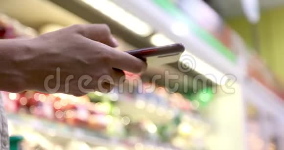 女士在超市用智能手机视频的预览图