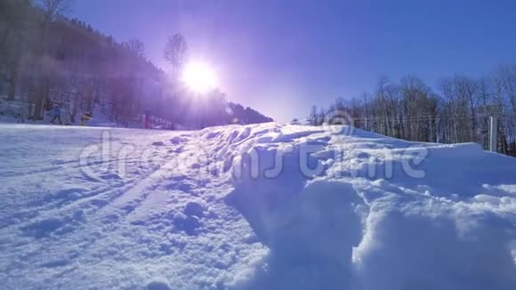 黄色动作年轻的职业滑雪者骑着半管在大山雪地公园在半管上喷洒雪到照相机里视频的预览图