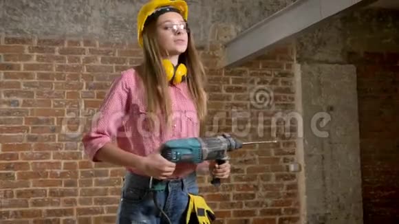 年轻漂亮的女孩建筑工人手里拿着钻打开微笑着建筑构思视频的预览图