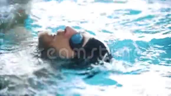 残疾人在游泳池的背部游泳近距离射击慢动作视频的预览图