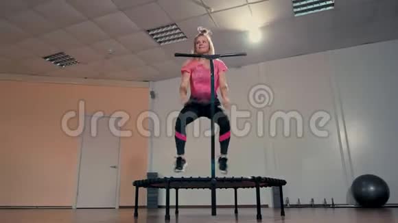在健身房的健身训练中运动的女人在蹦床上跳得很高视频的预览图