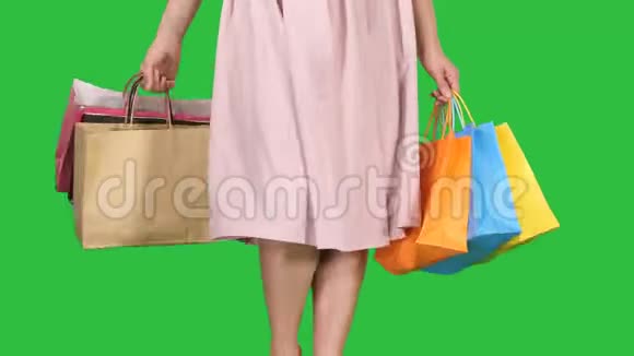 每天购物后年轻女子背着购物袋走在绿色屏幕上Chroma键视频的预览图