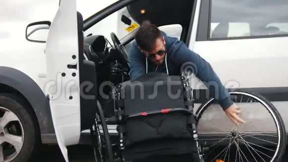 一个坐在车里的残疾人把他的轮椅放在了车里视频的预览图