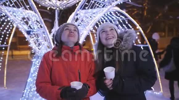 两个女孩在圣诞夜城市散步喝咖啡聊天视频的预览图