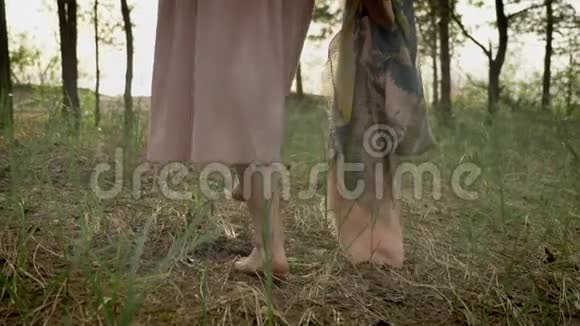 夏林中赤脚行走的小女孩公园里草地上散步的小女孩大自然概念50fps视频的预览图