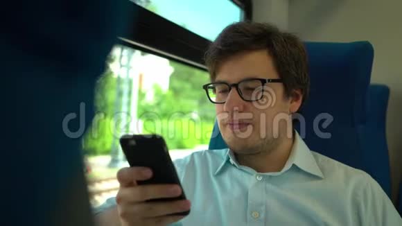 戴眼镜的中年男子坐火车拨打电话和打电话视频的预览图