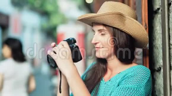 戴帽子的女游客用专业相机拍照的笑脸视频的预览图