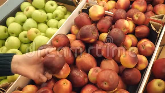 挑选新鲜红苹果的女人在杂货店生产超市销售视频的预览图