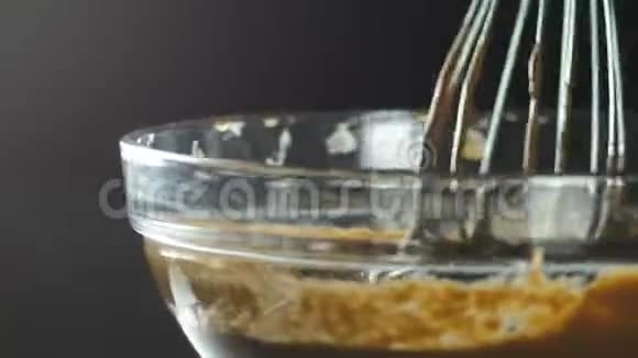 在一个玻璃容器中加入液态巧克力用搅拌器搅拌烹饪甜点为新年甜点结冰视频的预览图