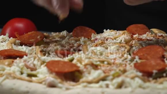 意大利辣香肠披萨的特写准备和加入意大利腊肠面团覆盖奶酪腌制黄瓜和酱汁视频的预览图