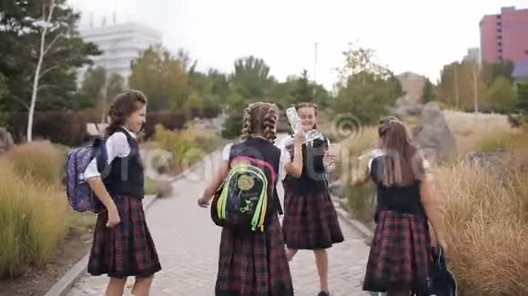 快乐的女大学生为课程的结束而欢欣鼓舞在公园里玩得开心视频的预览图
