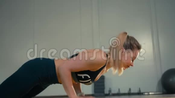 运动型苗条的白人女士正在健身房做俯卧撑视频的预览图