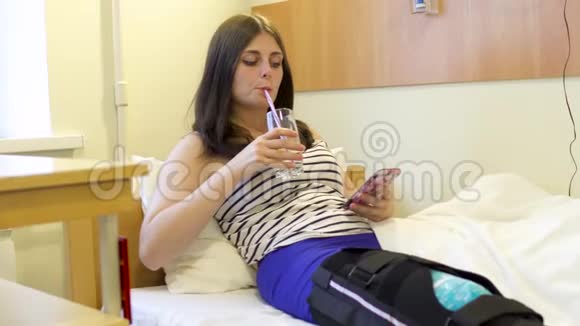 受伤的小女孩在医院里用手机喝水视频的预览图