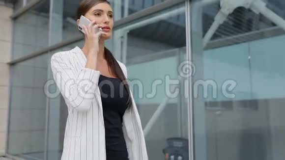 美丽的商务女性谈电话上班视频的预览图