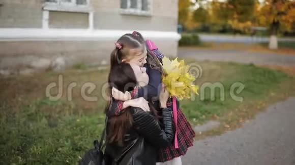 放学后母女俩拥抱在学校附近妈妈从学校接女儿视频的预览图