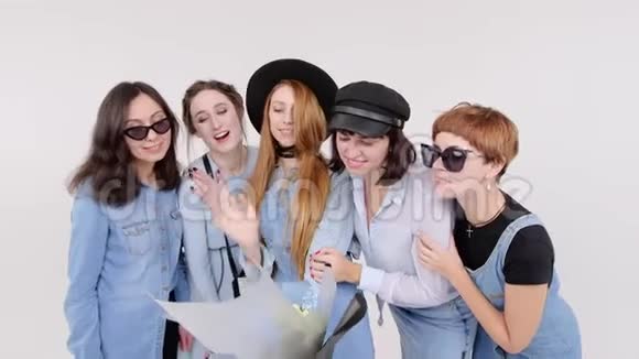 一群穿牛仔服装的女人在白色的工作室里摆姿势手里拿着一束花戴眼镜和帽子的妇女视频的预览图