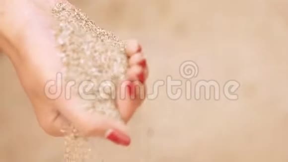 沙子从女人的手指滑过视频的预览图