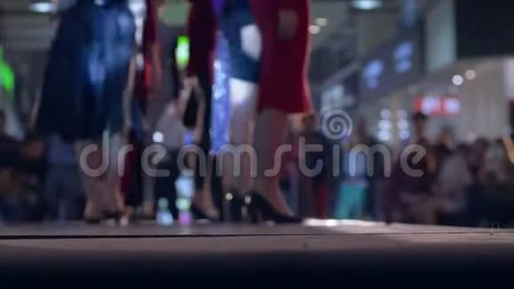 在时装秀期间女模特穿着高跟鞋摆姿势穿着不同的衣服走着跑道视频的预览图