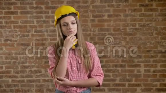 年轻漂亮的女孩建筑商站着评估某件事思考过程砖背景视频的预览图