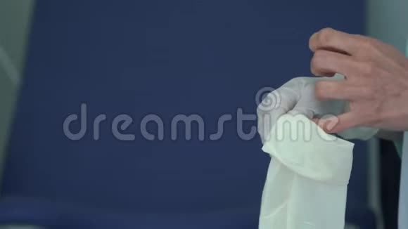 妇科医生在检查病人前把橡胶手套放在她的手上视频的预览图