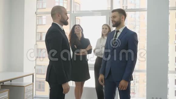 办公室工作人员两名年轻妇女和两名年轻男子两名男子相互交谈和同意两名妇女视频的预览图