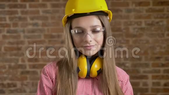 年轻漂亮的女建筑工人正点头示意目光移开看着镜头砖背景视频的预览图