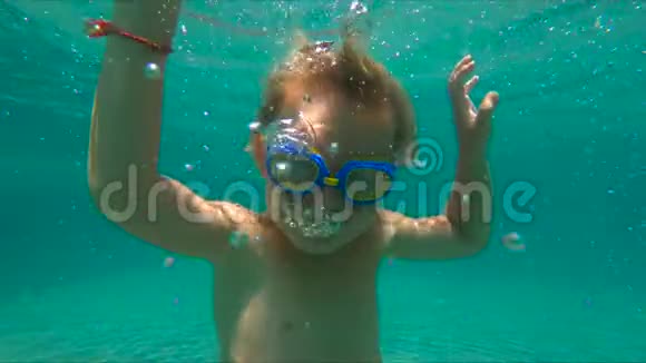 小男孩在游泳池里潜水和泡泡泡时的慢镜头视频的预览图