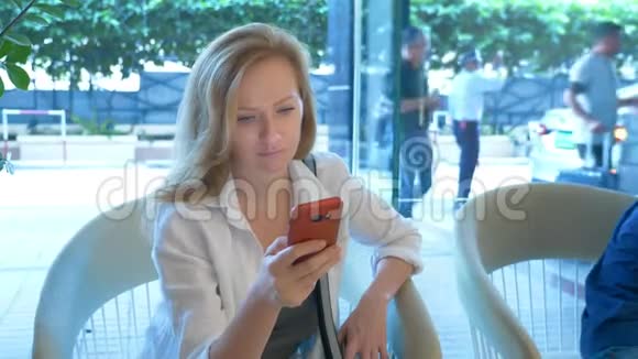 一个忙碌的女人在酒店大堂用电话视频的预览图