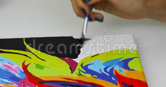 一个女孩在画布上用黑色颜料画画笔视频的预览图