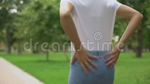 苗条的女人在公园散步感觉背痛不适风湿保健视频的预览图