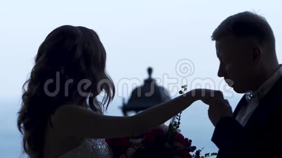 新郎亲吻新娘的手这对夫妇的剪影她在任何地方都看视频的预览图
