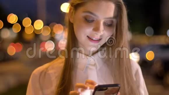 年轻漂亮的女孩在夏天的晚上在智能手机上输入信息做梦的概念交流的概念视频的预览图