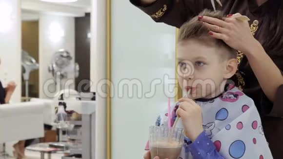 理发店理发时可爱的男孩喝鸡尾酒视频的预览图