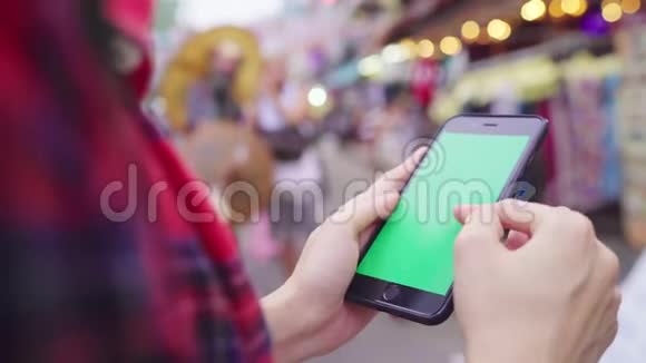 亚洲女性游客背包客微笑使用绿色屏幕智能手机独自旅行在城市街道户外度假视频的预览图