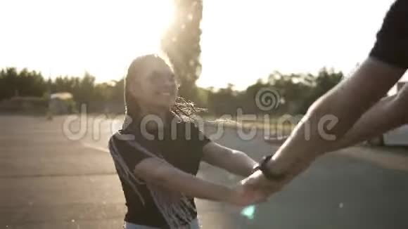 年轻快乐的夫妇在停车场一起玩牵手婆娑嬉笑穿着牛仔短裤视频的预览图