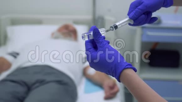 护士在注射器里注射一种药物病人在模糊的背景下躺在教练上视频的预览图