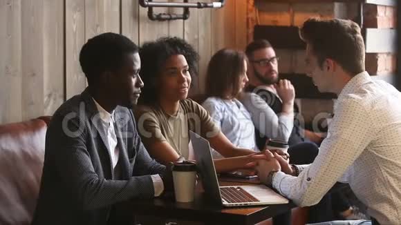 一对黑人夫妇在咖啡店里和白种人商人说话视频的预览图
